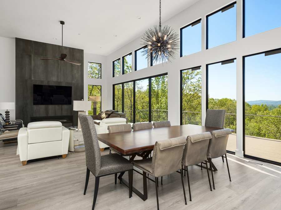Dining and living room with floor-to-ceiling windows and a mountain view