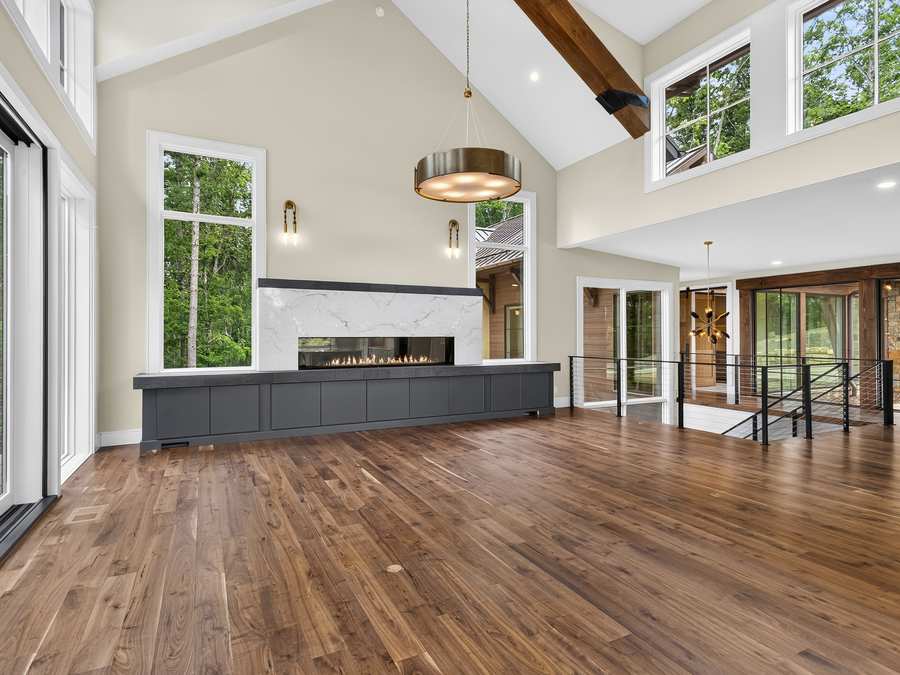 Great room with a stone fireplace and vaulted ceiling