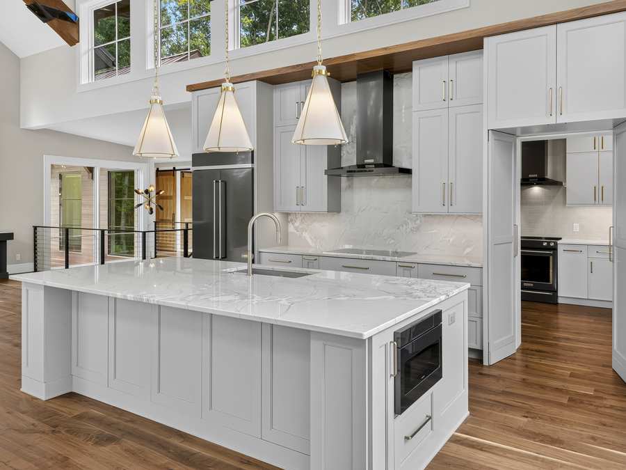 Kitchen with a marble island and pendant lights