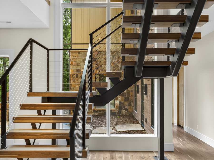 Floating stair with open wood treads and cable rail